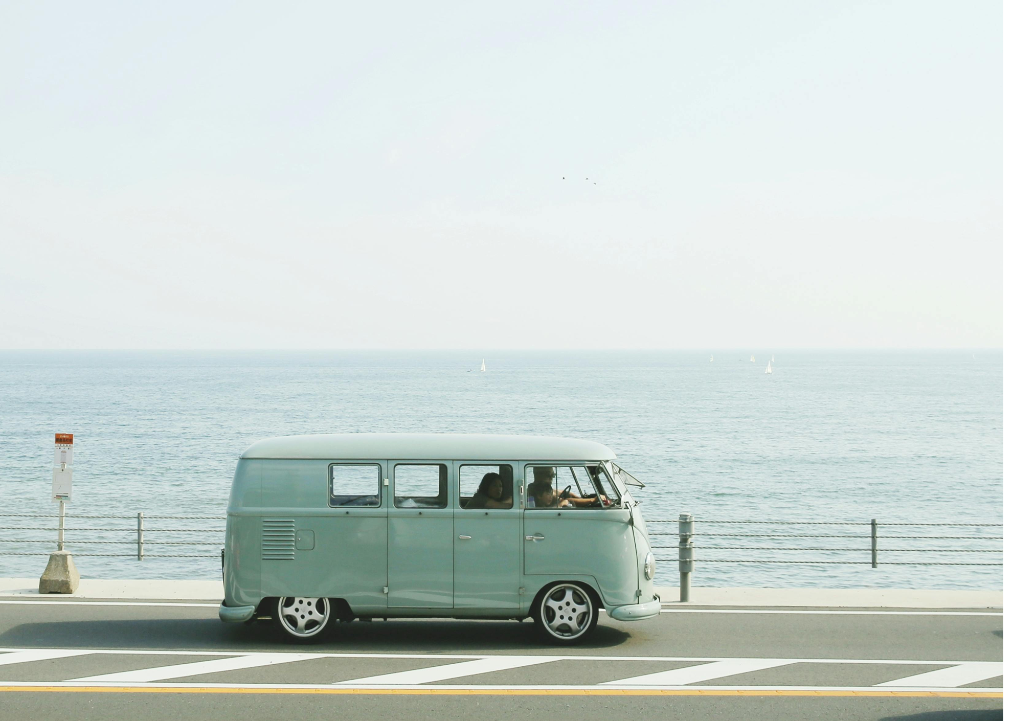 Kombi em uma estrada na beira do mar.